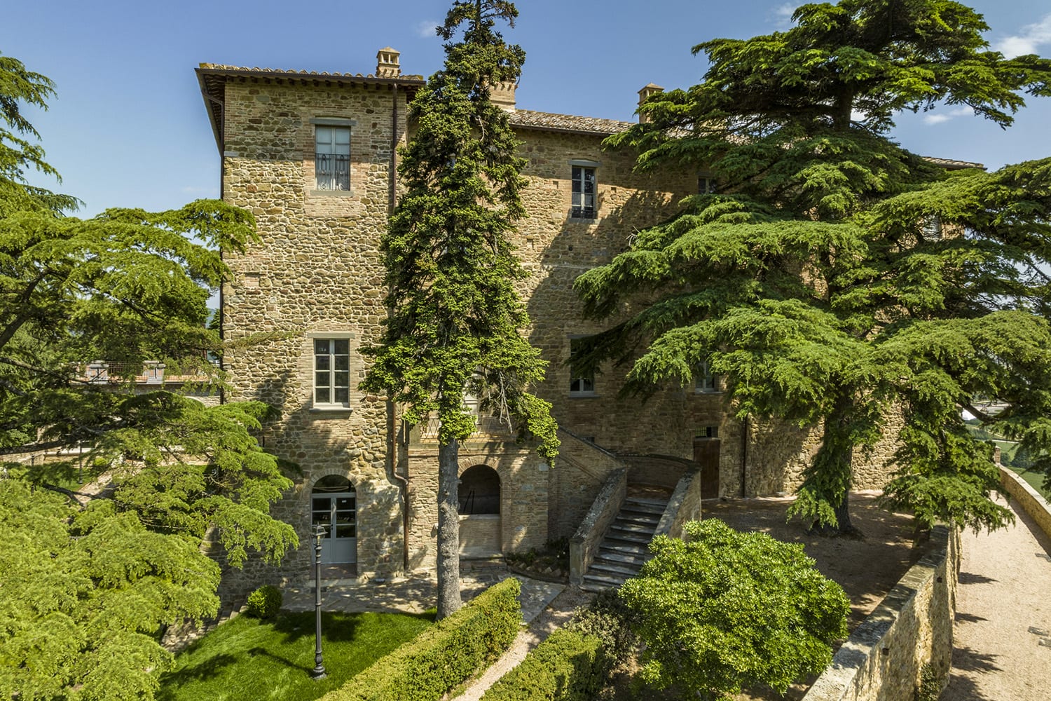 Scaletta in pietra fra ulivi e rose nel giardino del castello
